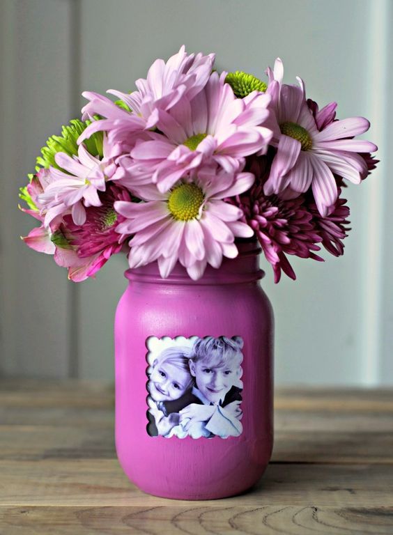 a purple mason jar with a kid's photo and pink flowers