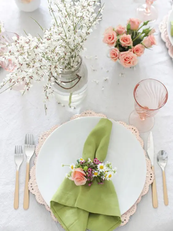 a rather neutral table is enlivened with a green napkin and some pink roses