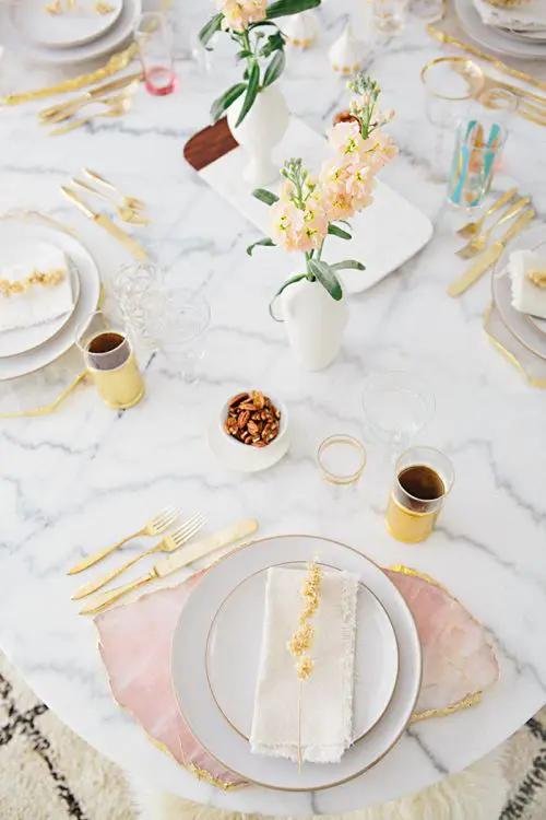 a modern tablescape on marble and with pink agate slices instead of placemats