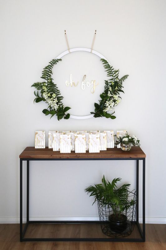 08 a modern greenery wreath with white blooms and a potted planter for favor table decor