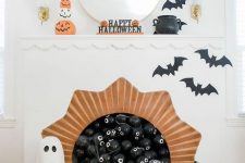 a classy Halloween fireplace with black eyed balls, black bats, ghosts and jack-o-lanterns