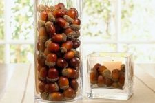 a glass with acorns and a square glass with a candle and acorns for decorating your space