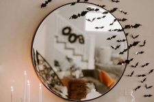 chic Halloween decor with bats, pumpkins, candles, a skull and some fog is a mistical decor idea