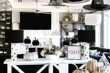 classic monochromatic Halloween decor with black and white pumpkins, witch hats, black and white arrangements and lamps