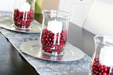 glass vases with pillar candles and cranberries for decorating the table for the fall