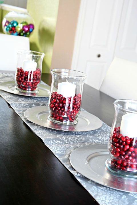 glass vases with pillar candles and cranberries for decorating the table for the fall
