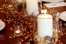 glasses with nuts and acorns and pillar candles for decorating the table for the fall