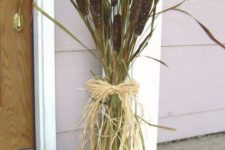 a cane and grass fall arrangement with hay and a woven tray is a cool idea for an outdoor space