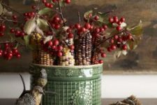 a fall arrangement of a green porcelain vase with berries and corn cobs is a lovely harvest centerpiece
