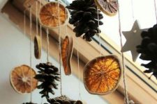 a fall window hanging of dried citrus slices and pinecones is a great decoration with a fall aroma