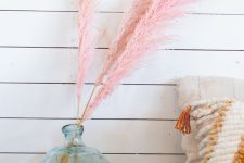 a large glass bottle with pink pampas grass is a playful and fun decoration you can easily make