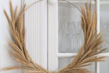 a modern fall wreath of a metal form and wheat is a great idea for fall or Thanksgiving