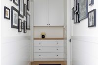 simple hallway design with a photo gallery wall and a built-in cabinet that provides linen storage