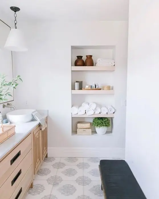 https://i.shelterness.com/2011/01/a-chic-modern-farmhouse-bathroom-with-a-timber-vanity-a-niche-with-shelves-used-for-storage-a-leather-bench.jpg
