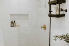 a modern farmhouse bathroom clad with skinny tiles, a timber vanity, black shelves and black handles, a niche in the shower