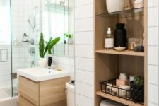 a modern farmhouse bathroom done in neutrals with shiplap walls, a timber niche with shelves fro storing everything you may need
