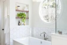 a modern neutral bathroom with white walls, printed and hexagon tiles, a rectangular tub, a niche with shelves and some lovely decor