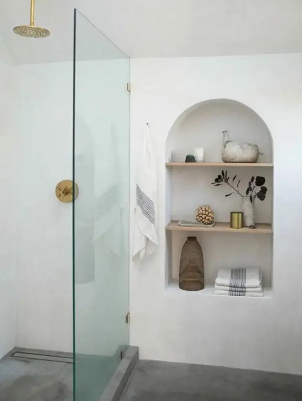 adding interest to the bathroom, an arched niche with shelves also provides the space with some storage