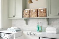 farmhouse sink and a marble countertop with a marble backsplash boost this laundry room to the next level