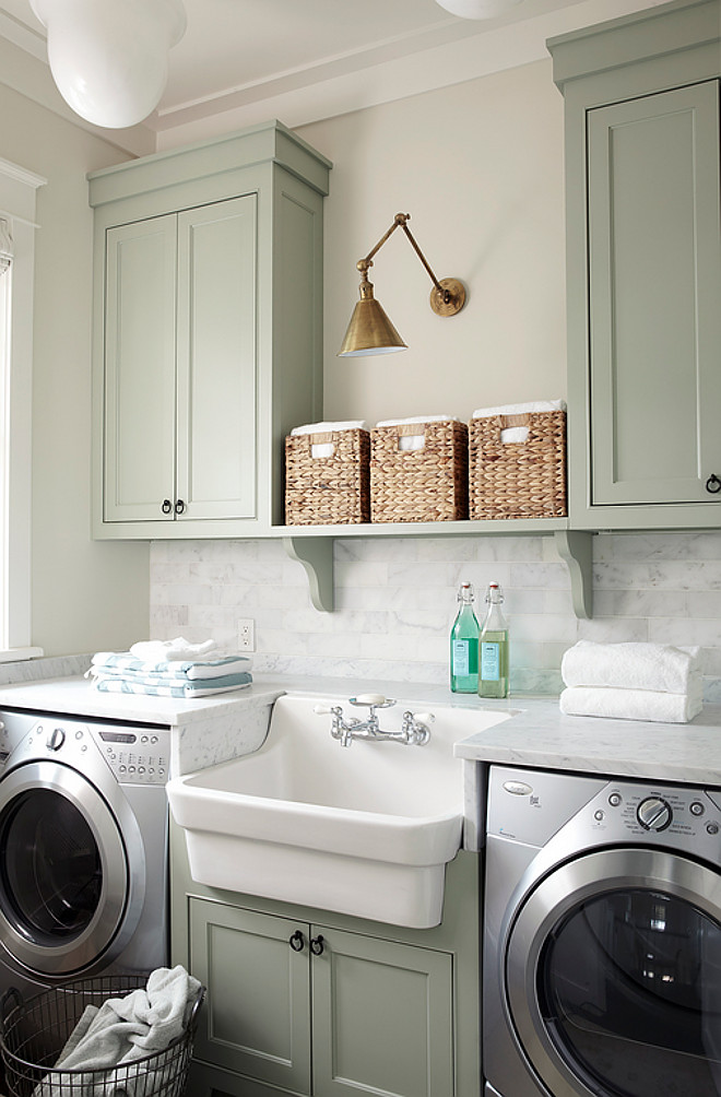 farmhouse sink and a marble countertop with a marble backsplash boost this laundry room to the next level