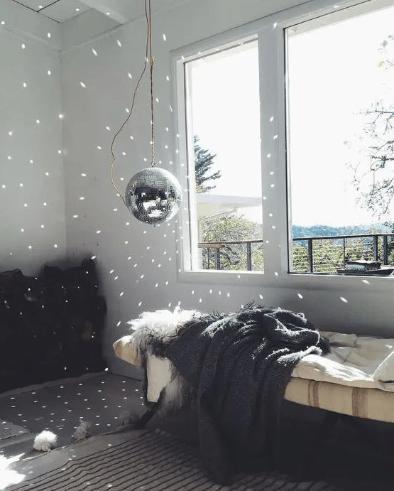 a disco ball hanging next to the window guarantees some fun and light even in the daytime