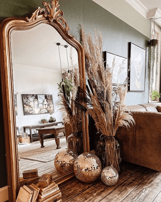a floor mirror in a chic vintage frame, with pampas grass and disco balls on the floor are a lovely combo for any space