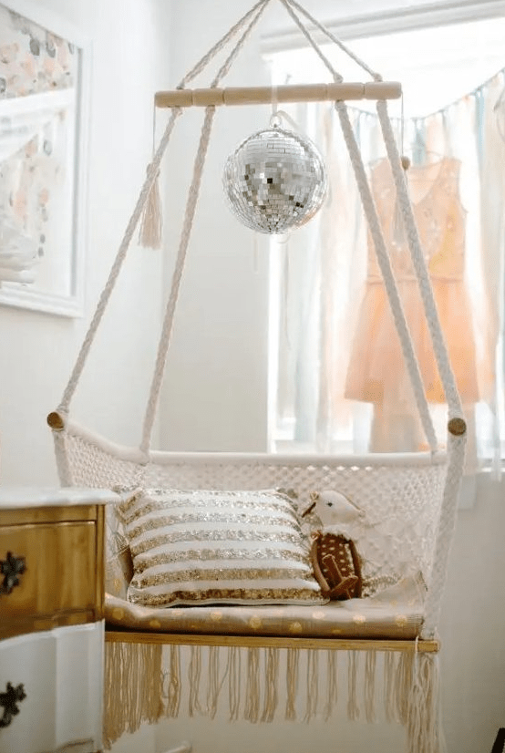 a macrame hammock chair with a disco ball for an accent are a lovely combo for a boho space, it's shiny and cool