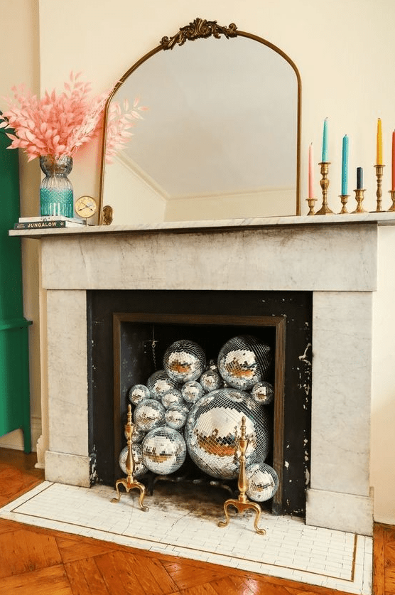 a non-working fireplace can be filled with silver disco balls to make it look chic and coo and add a fun accent to the space