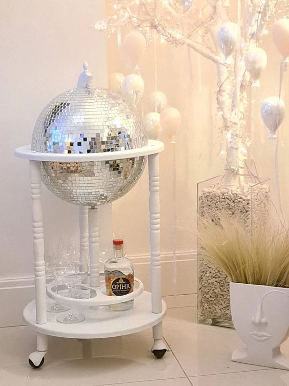 a white home bar of a disco ball on a stand with wheels is a cool idea for many homes