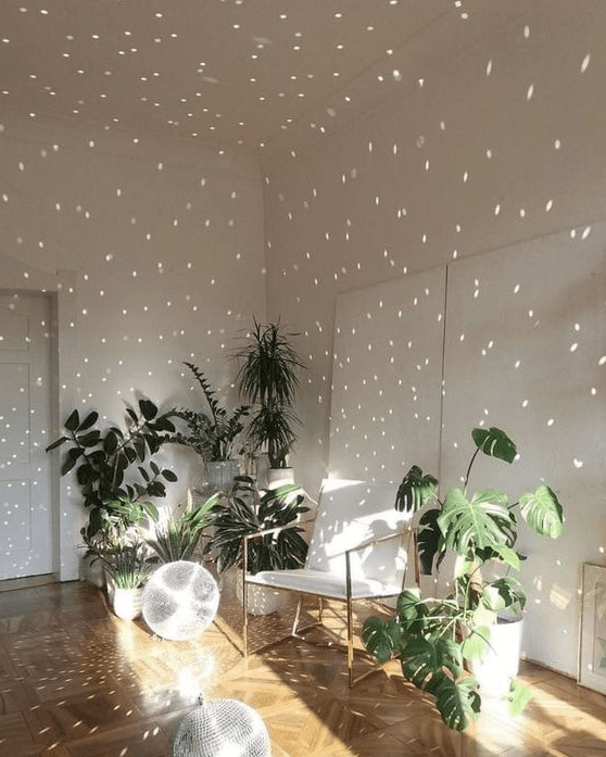 a white space with a chair. some plants and disco balls on the floor are a great solution for a modern living room