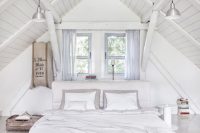 all white bedroom beneath the vaulted ceiling