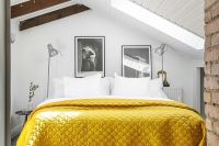 white attic bedroom with a touch of yellow and a brick wall