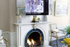 a fireplace and an artwork over it that hides a TV – open the doors and you will get your TV