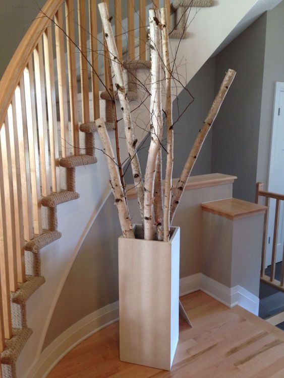 a tall square concrete vase with birch branches is a cool and fresh idea to decorate any space giving it a natural touch
