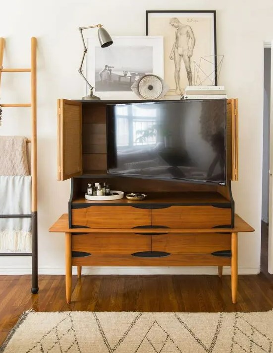 a vintage rich-stained storage cabinet that holds a TV and can hide it anytime with cane bi-fold doors is a lovely idea for a modern room