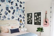 a guest bedroom with an abstract bright wallpaper wall with brushstrokes for a bold accent