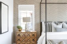 a neutral bedroom with a geometric print wallpaper wall that accents the space with pattern and colors