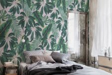 a rough industrial bedroom softened with a tropical print wallpaper accent wall for a bold touch