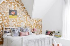 an attic bedroom with a mustard floral print wall for a touch of color and pattern in the space