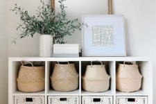 an entryway console table with baskets and white wicker cubbies allows storage without cluttering