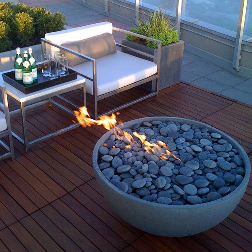 a concrete fire bowl with grey pebbles looks very contemporary and makes your space very cozy