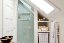 a tiny contemporary attic bathroom with mother of pearl hex tiles, a shower with a skylight and some storage space
