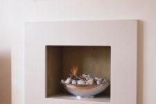an elegant gas fire bowl with pebbles in it is a chic onctemporary decor idea
