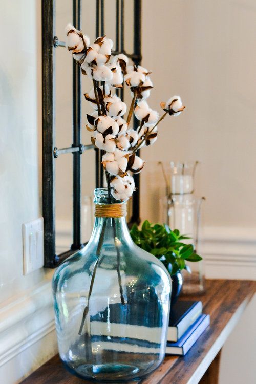 an oversized blue bottle with twine and cotton branches is a cute farmhouse-inspired decoration to rock