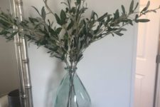 an oversized bottle in the corner with greenery branches is a very cool decoration to rock