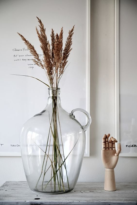 an oversized bottle with dried herbs is a cool decoration to rock for any space that lacks a natural touch