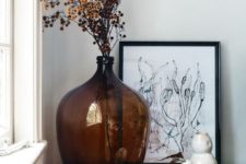 an oversized brown bottle with dried blooms is a cool decoration for any space