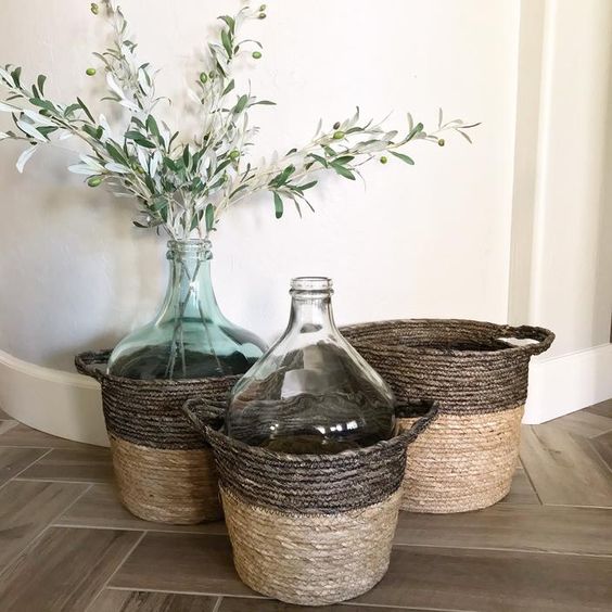 baskets with oversized bottles, with greenery and olive branches add a farmhouse feel to the space