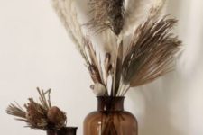 brown apothecary bottles with pampas grass and dried proteas are chic and cool decor for any space