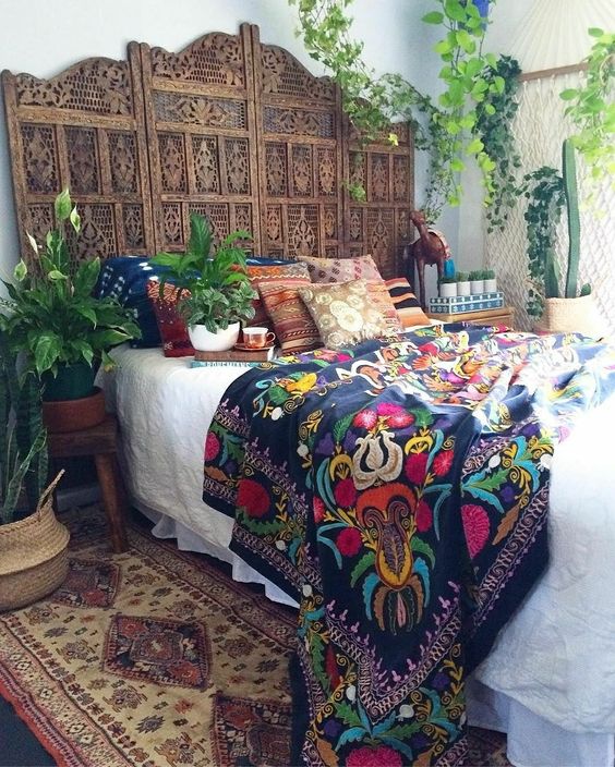 a boho wooden carved headboard made of a wooden screen is a stylish idea for a free spirited bedroom